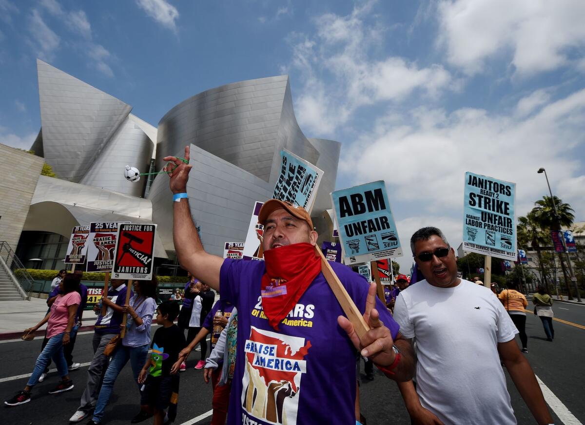 A group of janitors estimated by police to number 3,000 marches through downtown Los Angeles on April 29, 2016, as they demonstrate over wages and threaten to strike.