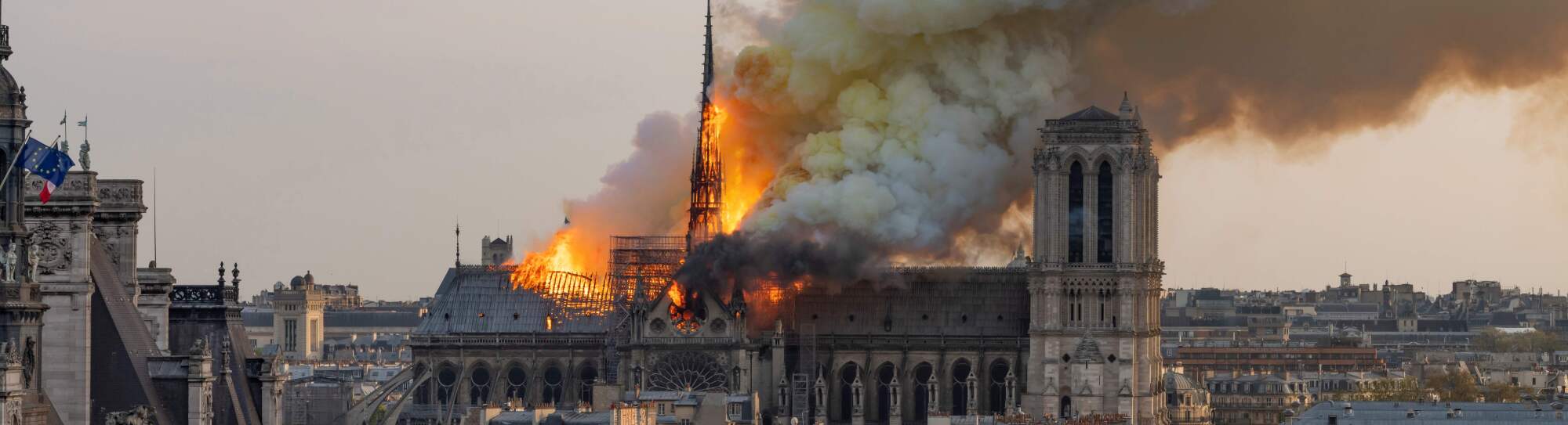 TOPSHOT - Smoke billows as flames burn through the roof of the Notre-Dame de Paris Cathedral on April 15, 2019, in the French capital Paris. - A huge fire swept through the roof of the famed Notre-Dame Cathedral in central Paris on April 15, 2019, sending flames and huge clouds of grey smoke billowing into the sky. The flames and smoke plumed from the spire and roof of the gothic cathedral, visited by millions of people a year. A spokesman for the cathedral told AFP that the wooden structure supporting the roof was being gutted by the blaze. (Photo by Fabien Barrau / AFP) (Photo credit should read FABIEN BARRAU/AFP via Getty Images)