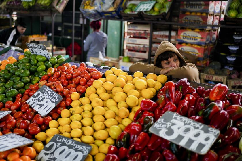 A vendor waits for customers at the central market for fruit and vegetables in Buenos Aires, Argentina, Friday, May 10, 2024. (AP Photo/Natacha Pisarenko)