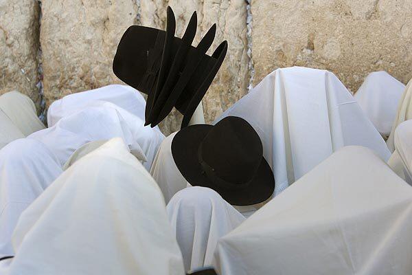Jewish men are draped in prayer shawls during the annual blessing celebration of Sukkot at the Western Wall in Jerusalem.