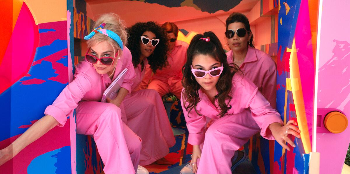 Barbie and Gloria lead a pink-suited crew on a mission in "Barbie."