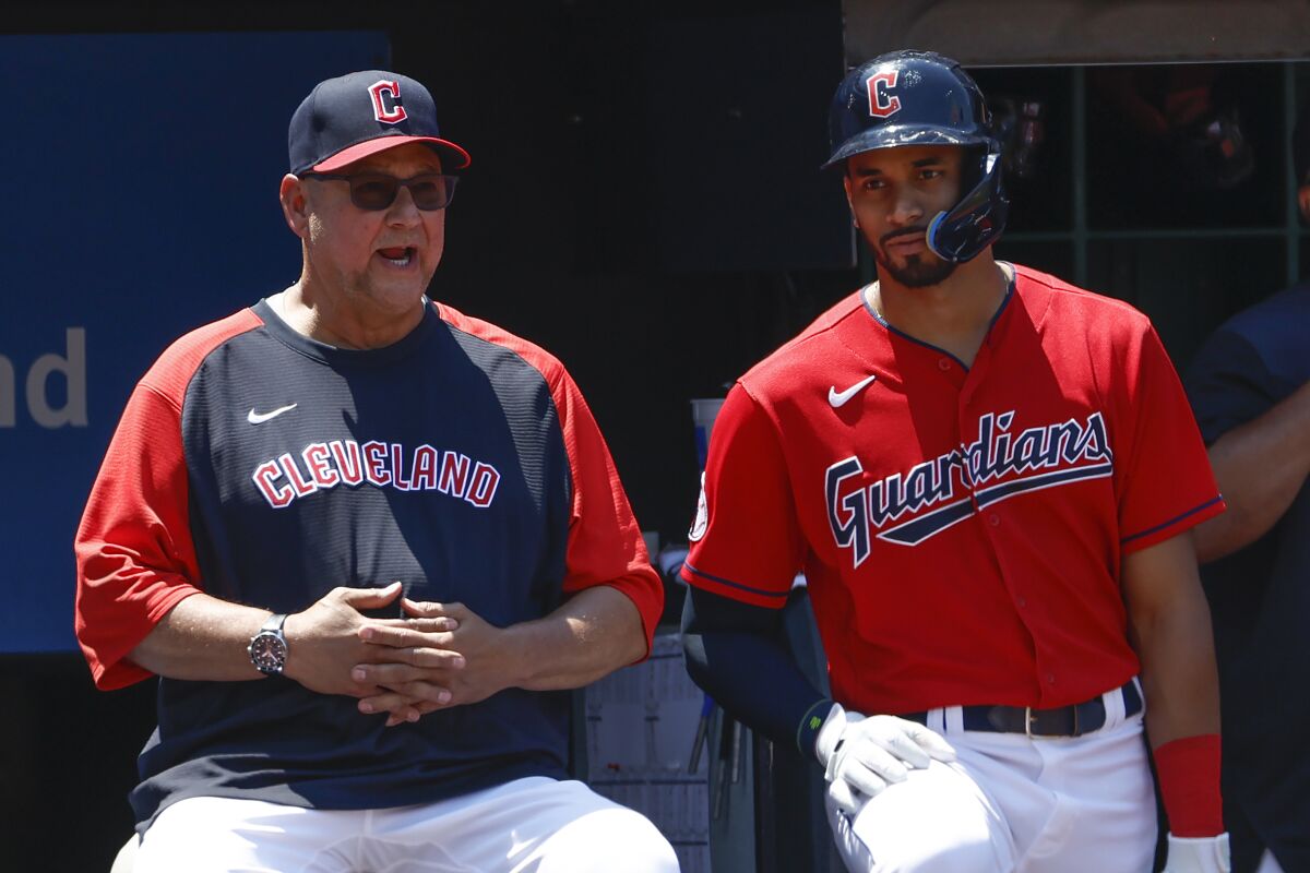 Cleveland Guardians manager Terry Francona, left, talks with Oscar Mercado during the eighth inning of a baseball game against the Oakland Athletics, Sunday, June 12, 2022, in Cleveland. (AP Photo/Ron Schwane)