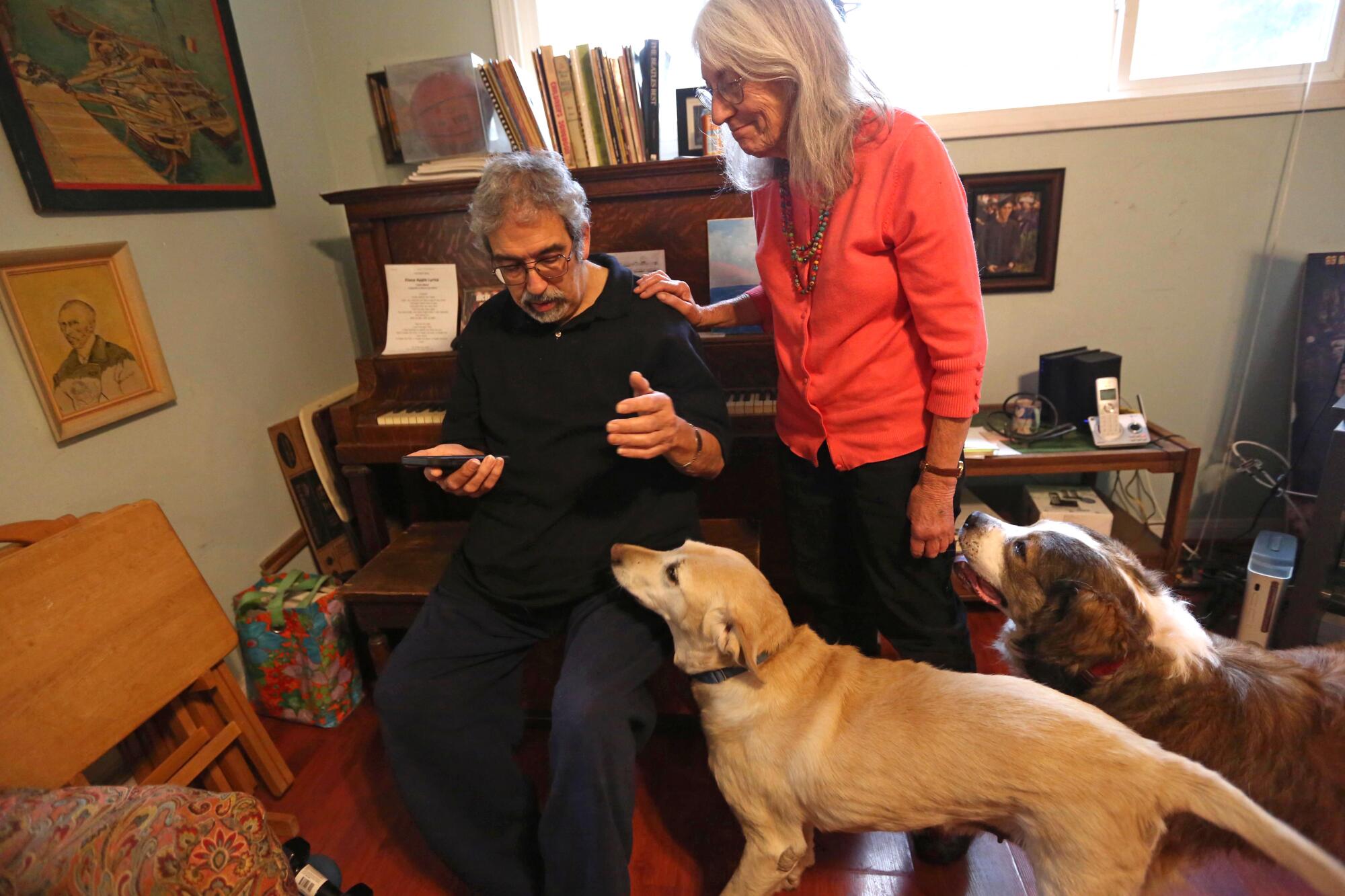 A man and a woman next to two dogs