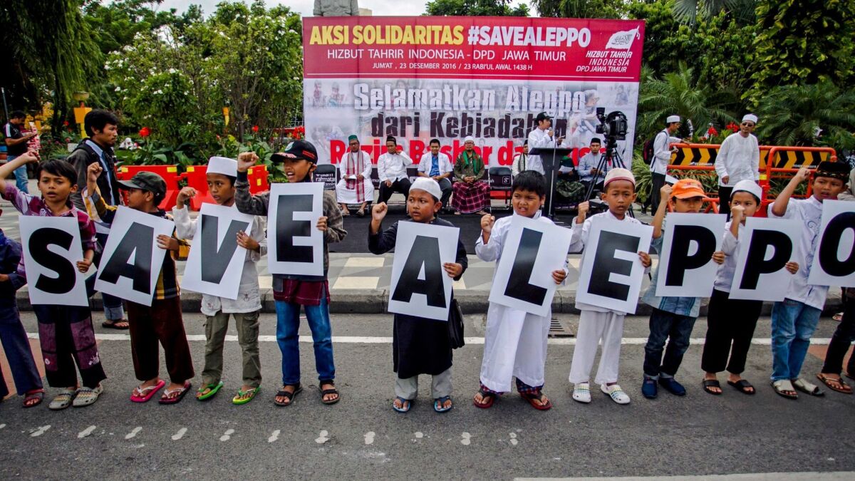Indonesian children hold banners 'Save Aleppo' during a rally in Surabaya, East Java, Indonesia