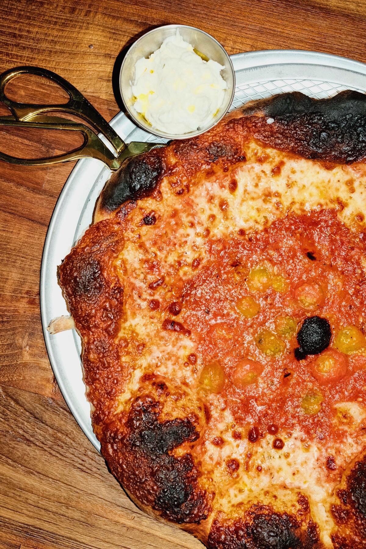 A vertical overhead photo of the Re-Marinara pizza at Leopardo. Scissors and a side of stracciatella at upper left corner.