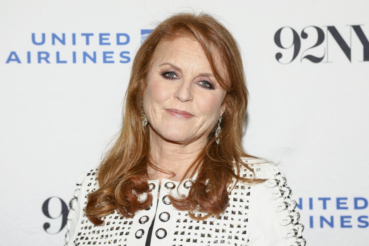 Sarah Ferguson, Duchess of York, wears white blouse with squares cut out of the fabric as she poses for a photo on red carpet