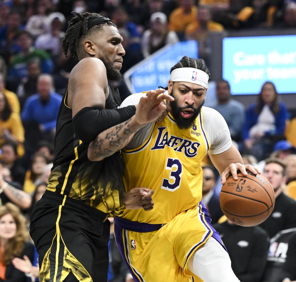 Lakers forward Anthony Davis, right, tries to power his way past Warriors forward Kevon Looney.