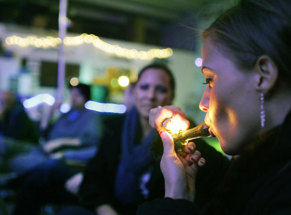 En esta fotografía de archivo del 31 de diciembre de 2012, Rachel Schaefer de Denver fuma marihuana en la inauguración del Club 64, un club social enfocado en la hierba, donde se llevó a cabo una fiesta por el Año Nuevo, en Denver. En esta ciudad se realiza una campaña para preguntarle a los electores en las boletas de noviembre si se debe permitir el consumo de marihuana en bares y otros sitios a los que sólo pueden asistir personas mayores de 21 años.