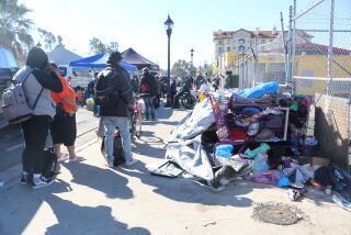 Members of a coordinated outreach event talk with unsheltered people in downtown San Diego.