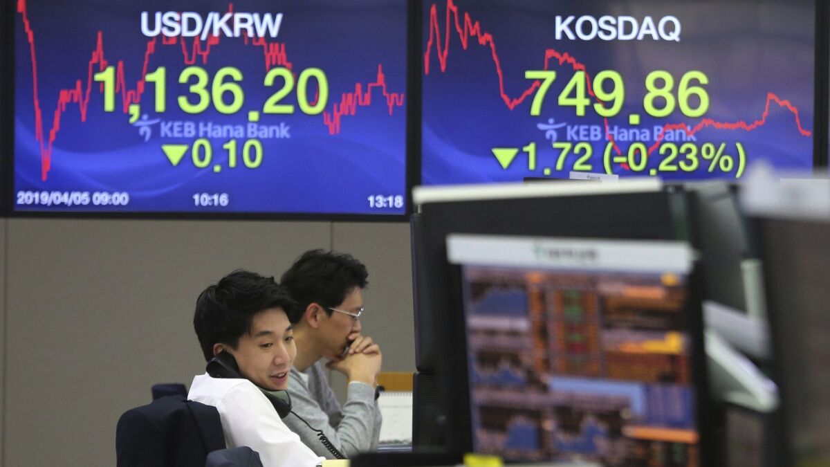 A currency trader talks on the phone at the foreign exchange dealing room of the KEB Hana Bank headquarters in Seoul on Friday.