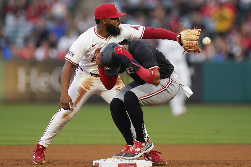 Minnesota Twins' Willi Castro, bottom, steals second base on a throwing error.