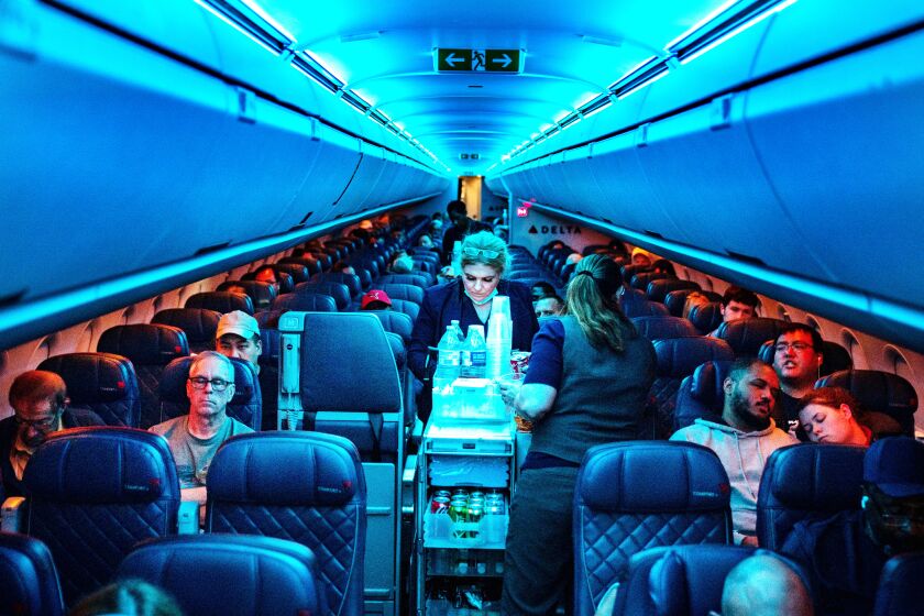 ATLANTA, GA - AUGUST 01: Flight attendants serve refreshments on a Delta Airlines flight from Hartsfield-Jackson International Airport on Monday, Aug. 1, 2022 in Atlanta, GA. (Kent Nishimura / Los Angeles Times)