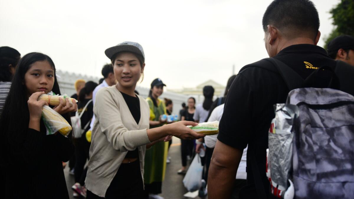 Volunteers distributing snacks and water to Thais mourning their king outside Bangkok's Grand Palace on Sunday.