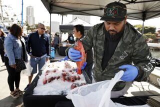 3080460_sd_me_tuna_festival_NL San Diego, CA May 18, 2019 Saturday's Tuna Harbor Fisherman's Festival, an open-air dockside seafood market, showcased the local tuna industry and sustainable seafood. Attractions included fishermen filleting fresh caught fish, longtime fishing families, who have made their livelihoods here for generations, fresh food tastings, were available to chat, and a touch tank where attendees were able to touch a variety of live crabs and a live sea urchin. Here, Eric Tapia of Three Boys, bags rock fish for a waiting customer. © 2019 Nancee E. Lewis / Nancee Lewis Photography. No other reproduction allow with out consent of licensor. Permission for advertising reproduction required.