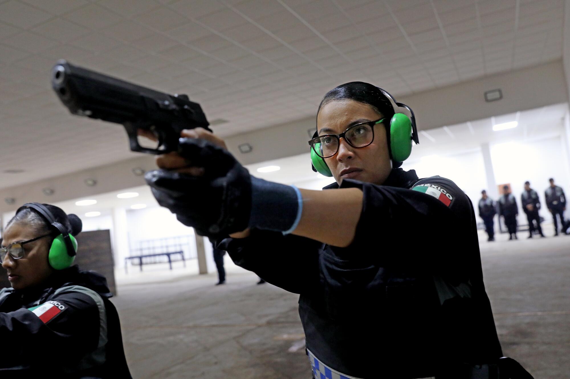 A woman holds a gun at a practice range. 