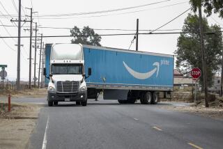 Ontario, CA - July 27: Amazon truck negotiates a sharp on 8000 block of Schaefer Avenue on its way to truck park parking on Wednesday, July 27, 2022 in Ontario, CA. (Irfan Khan / Los Angeles Times)