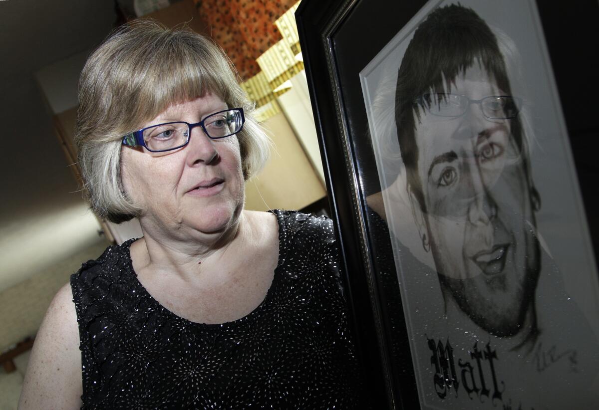 Jerri Jackson, mother of Aurora, Colo., theater shooting victim Matthew McQuinn, stands next to a sketch of her son.