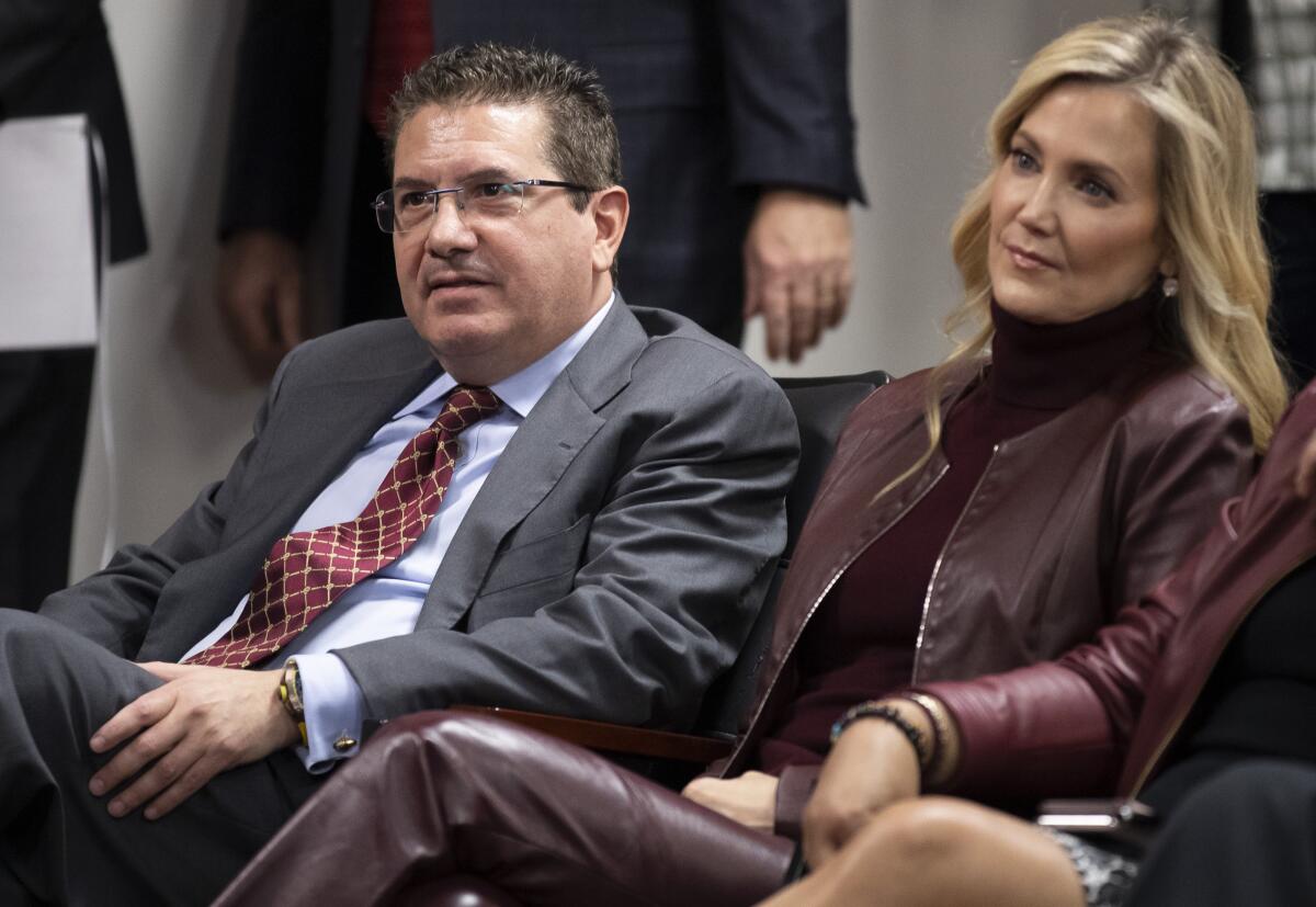 Washington Commanders owners Dan and Tanya Snyder, listen to head coach Ron Rivera during a news conference