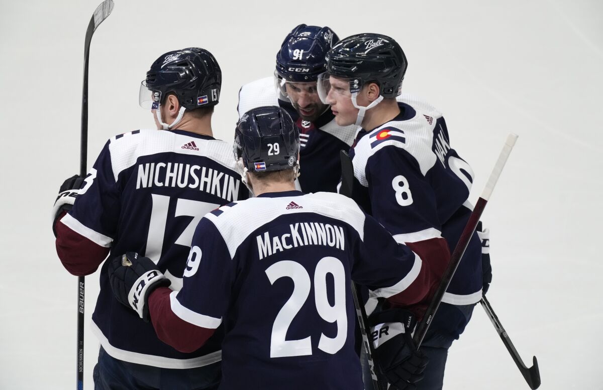 Colorado Avalanche defenseman Cale Makar, right, is congratulated by right wing Valeri Nichushkin, left, center Nathan MacKinnon, front center, and center Nazem Kadri for Makar's goal during the first period of an NHL hockey game against the Nashville Predators on Thursday, April 28, 2022, in Denver. (AP Photo/David Zalubowski)