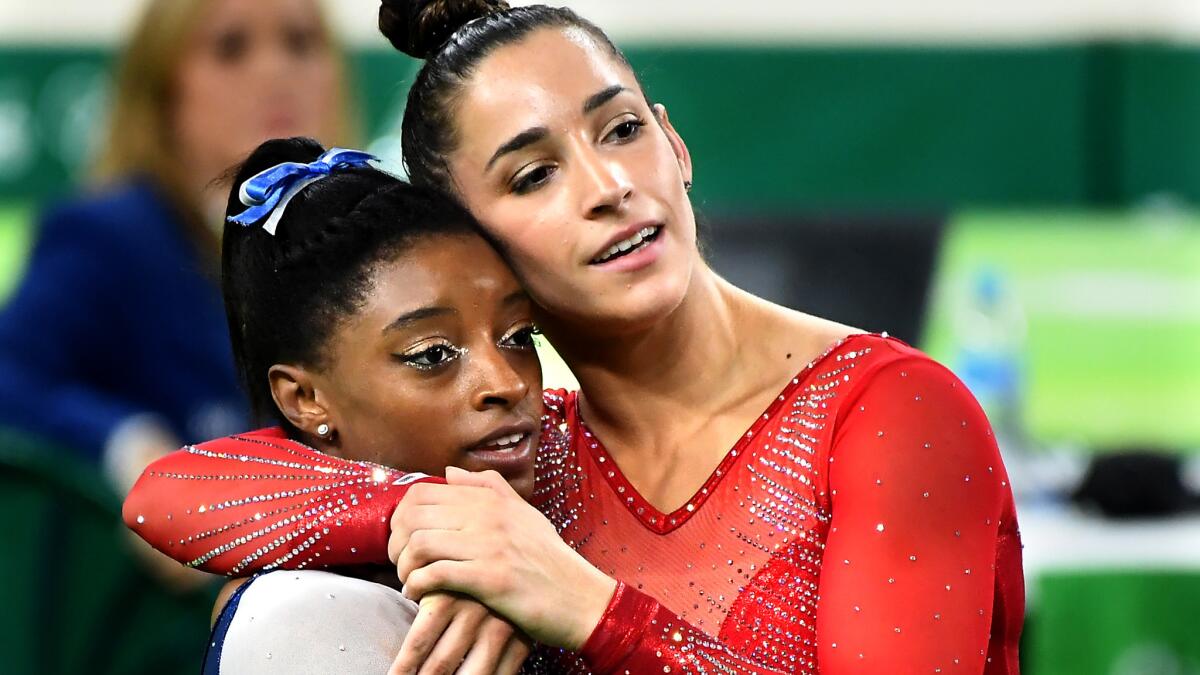 Simone Biles, left, and Aly Raisman embrace after clinching their gold and silver medals in the women's gymnastics all-around event Thursday.