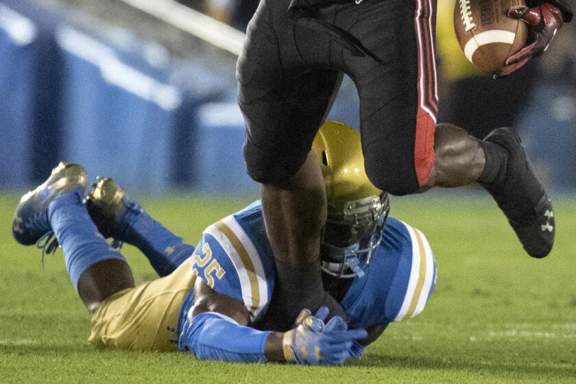 FILE - In this Oct. 26, 2018, file photo, Utah running back Zack Moss, top, sprints over a tackle by UCLA linebacker Tyree Thompson during the first half of an NCAA college football game, in Pasadena, Calif. Moss turned more than a few heads when he chose to return to Utah for his senior season. The decision felt like a simple one for Moss. He wanted to be the first in his family to graduate with a college degree. The 5-foot-10 running back also believed he had some unfinished business on the field. (AP Photo/Kyusung Gong, File)