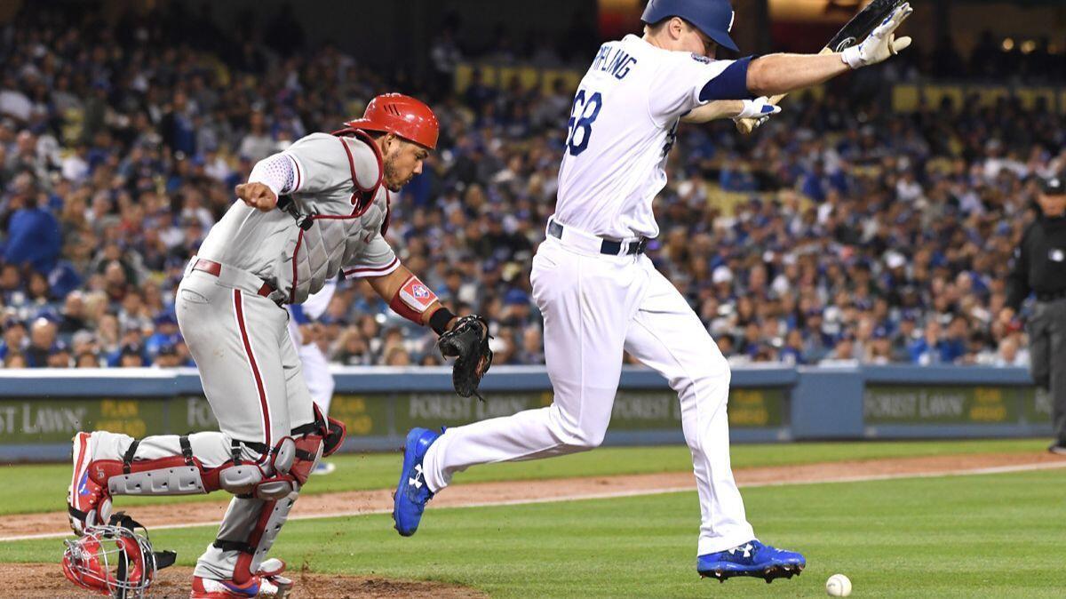 Dodgers pitcher Ross Stripling lays down a sacrifice bunt to load the bases as Philadelphia Phillies catcher Jorge Alfaro chases the baseball in the fourth inning at Dodger Stadium on Wednesday.