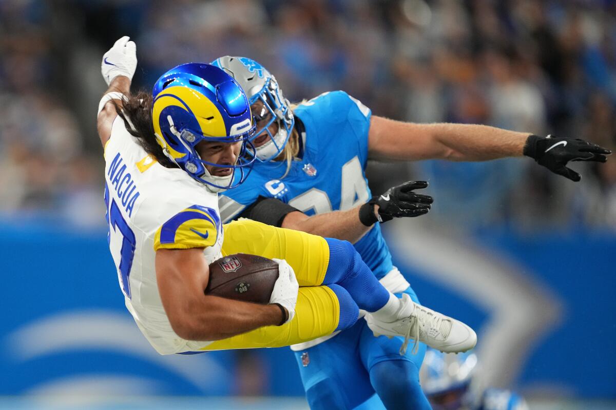 Rams receiver Puka Nacua is pushed out of bounds by the Lions' Alex Anzalone. 