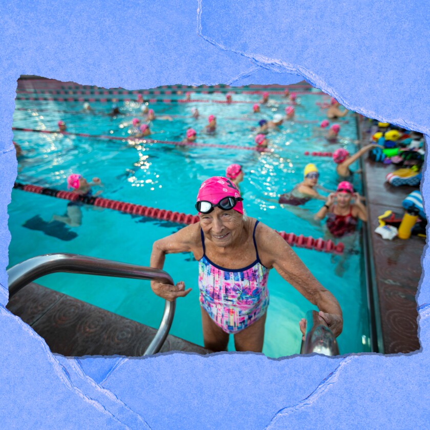 Una anciana en traje de baño sale de una piscina llena de gente.