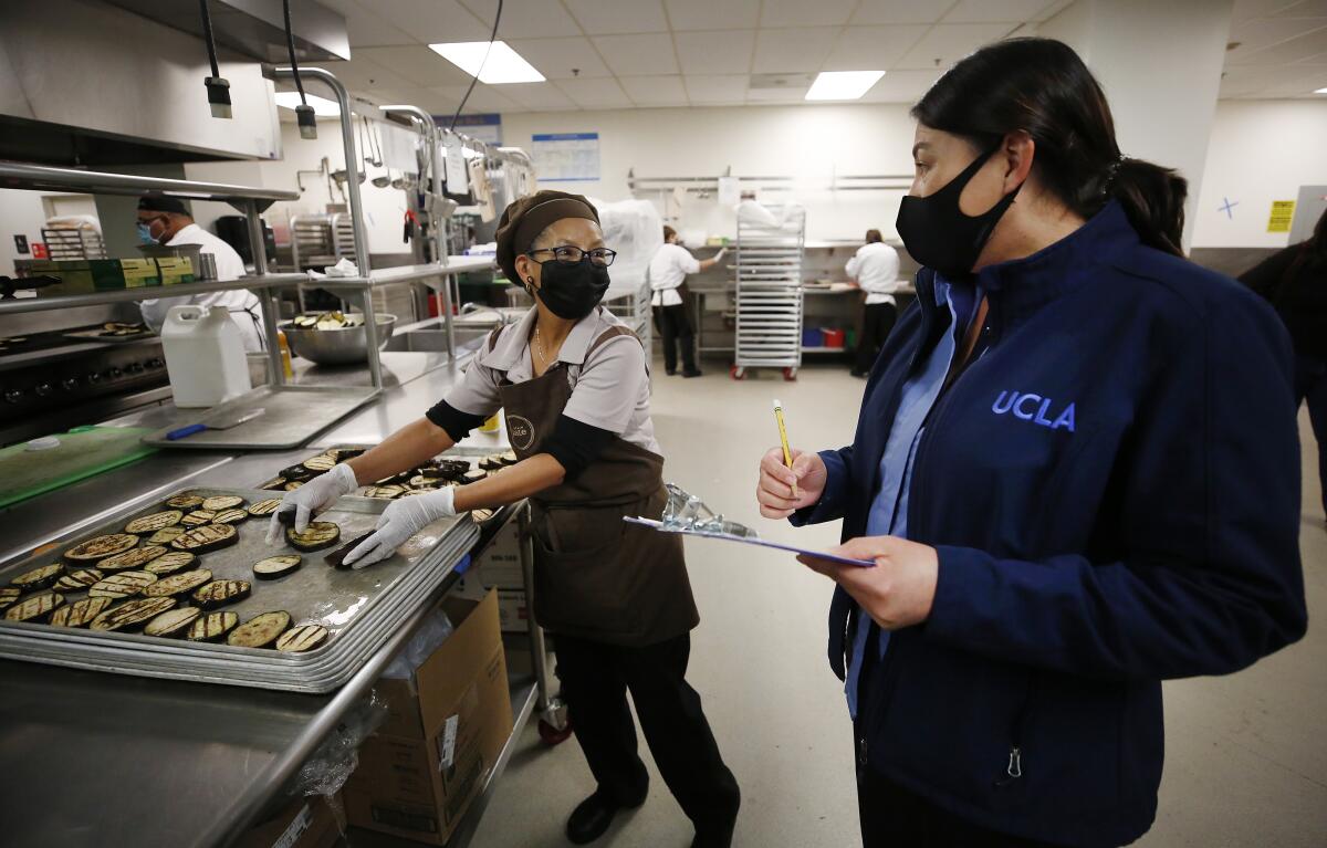 UCLA food service employees at work in a kitchen.