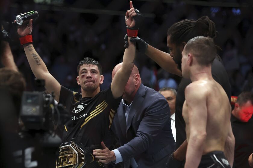 Brandon Moreno raises his arms as he is declared the winner in a mixed martial arts interim flyweight bout against Kai Kara-France at UFC 277 on Saturday, July 30, 2022, in Dallas. (AP Photo/Richard W. Rodriguez)