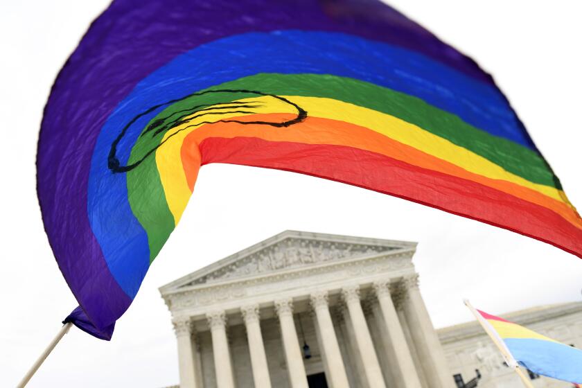 FILE - In this Oct. 8, 2019, file photo, people gather outside the Supreme Court in Washington. A federal judge has blocked the Trump administration from enforcing a new regulation that would roll back health care protections for transgender people. The regulation from the federal Department of Health and Human Services was finalized days after the Supreme Court barred sex discrimination against LGBT individuals on the job. (AP Photo/Susan Walsh, File)