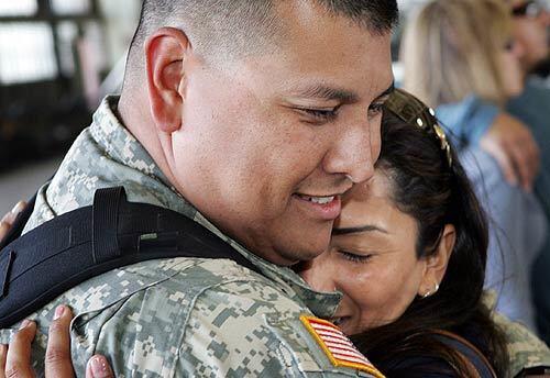 California Army National Guard Staff Sgt. Michael Caudillo, above, hugs his wife, Bianca, after returning Sunday from Camp Bucca, Iraq, near the Kuwaiti border.