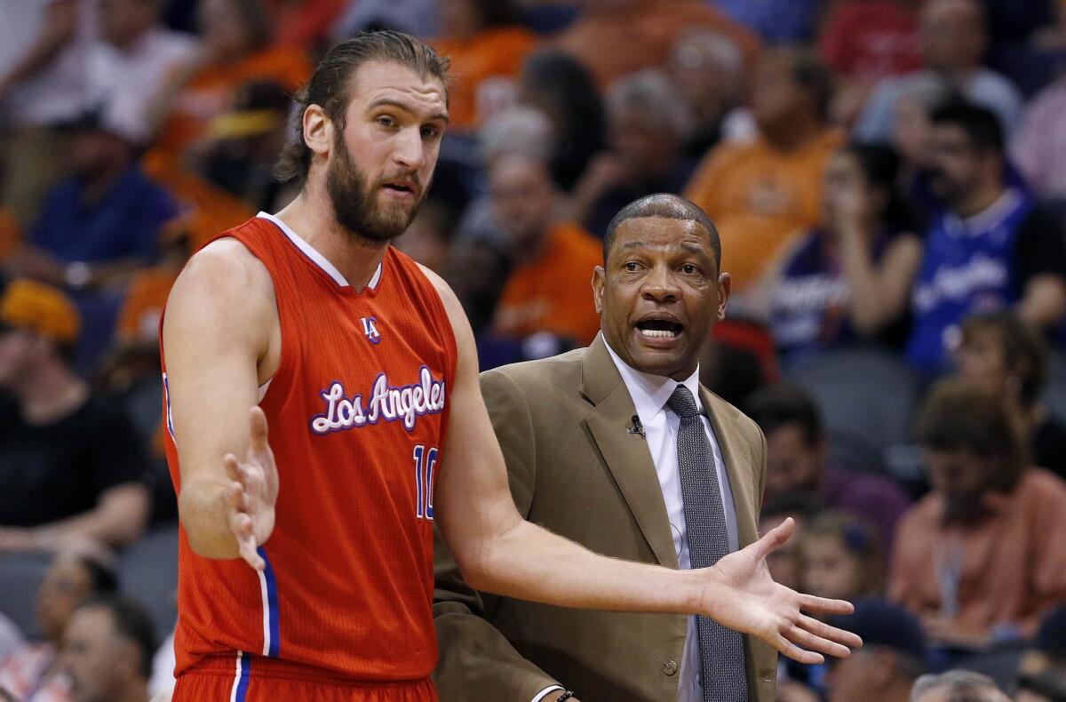 Clippers Coach Doc Rivers talks with Spencer Hawes during a game against the Suns in Phoenix on April 14.