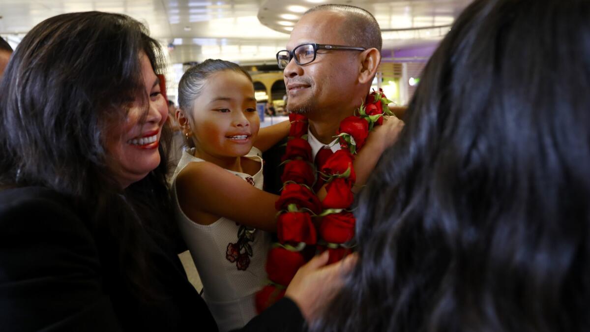 Meach Sovannara, center, at LAX on Saturday greets family including his wife, Jamie Meach, left, and youngest daughter, Sarai Sovannara, 10.