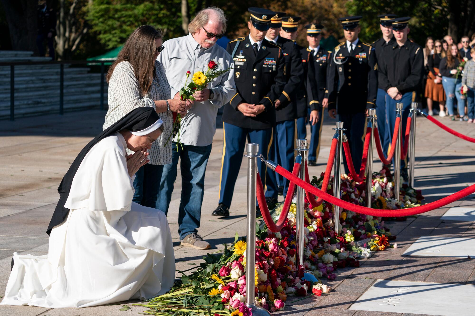A nun prays after placing flowers  at the Tomb of the Unknowns