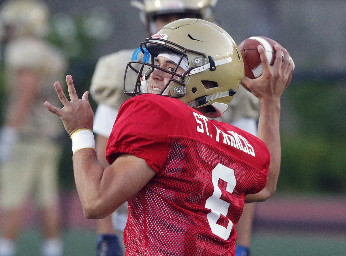 St. Francis quarterback Jack Clougherty leans back to pass the ball as he and his team practice plays at a preseason football practice at St. Francis High School on Thursday, August 15, 2019.