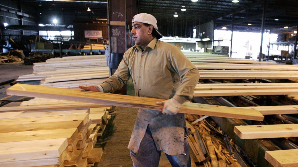 A worker sorts and stacks lumber at the Pan Abode Mill in British Columbia