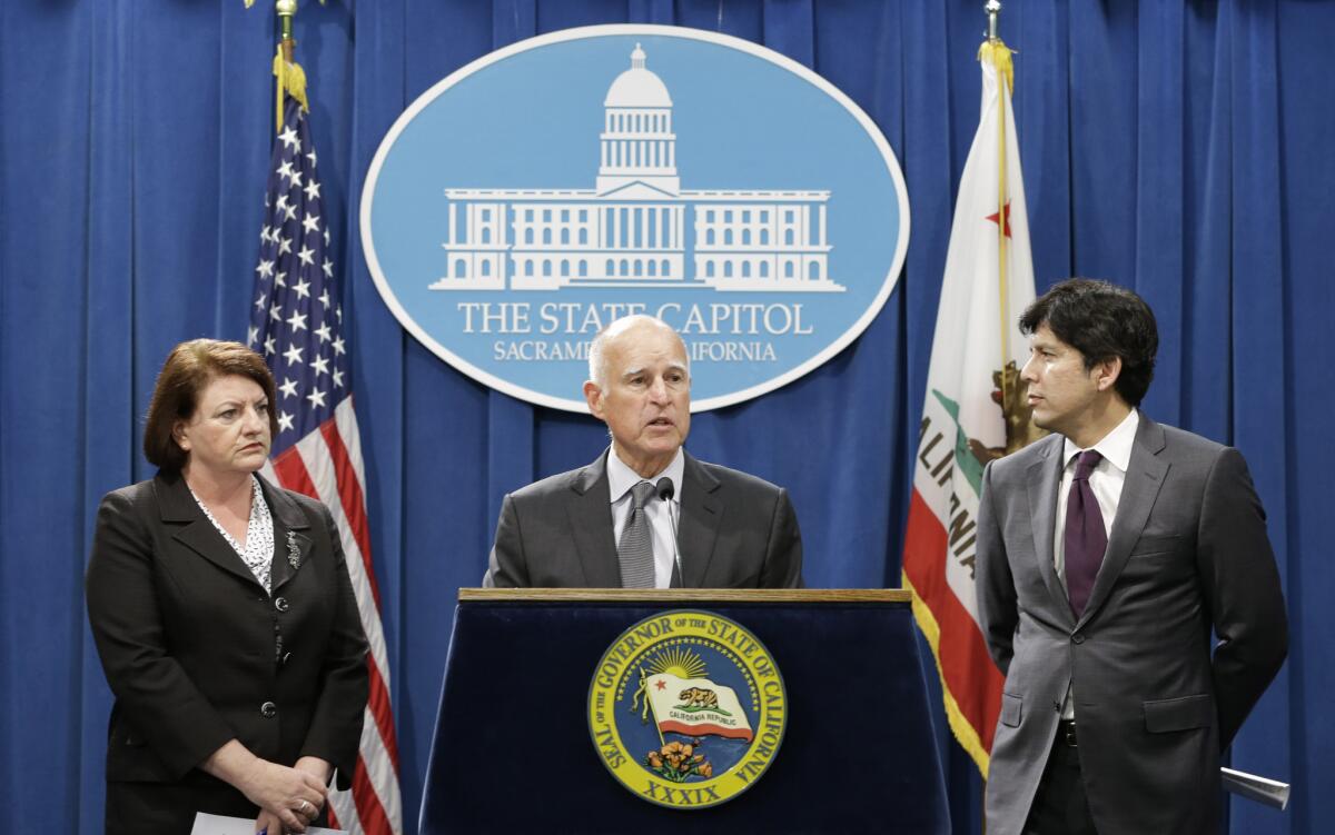 Gov. Jerry Brown, Assembly Speaker Toni Atkins (D-San Diego), left, and Senate leader Kevin de León (D-Los Angeles), right, announce a budget deal on Tuesday in the Capitol.
