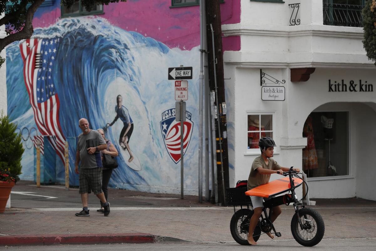 Residents and tourists walk along Avenida Del Mar on Thursday.