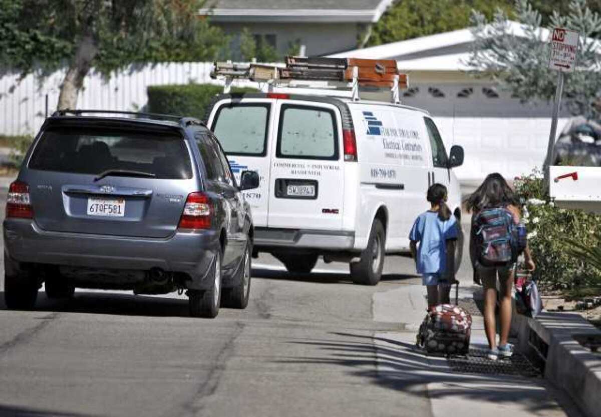 Cars take a wide right turn to avoid La Canada Elementary school students walking on Fairview Drive at Angeles Crest Highway on Thursday, Sept. 20, 2012.