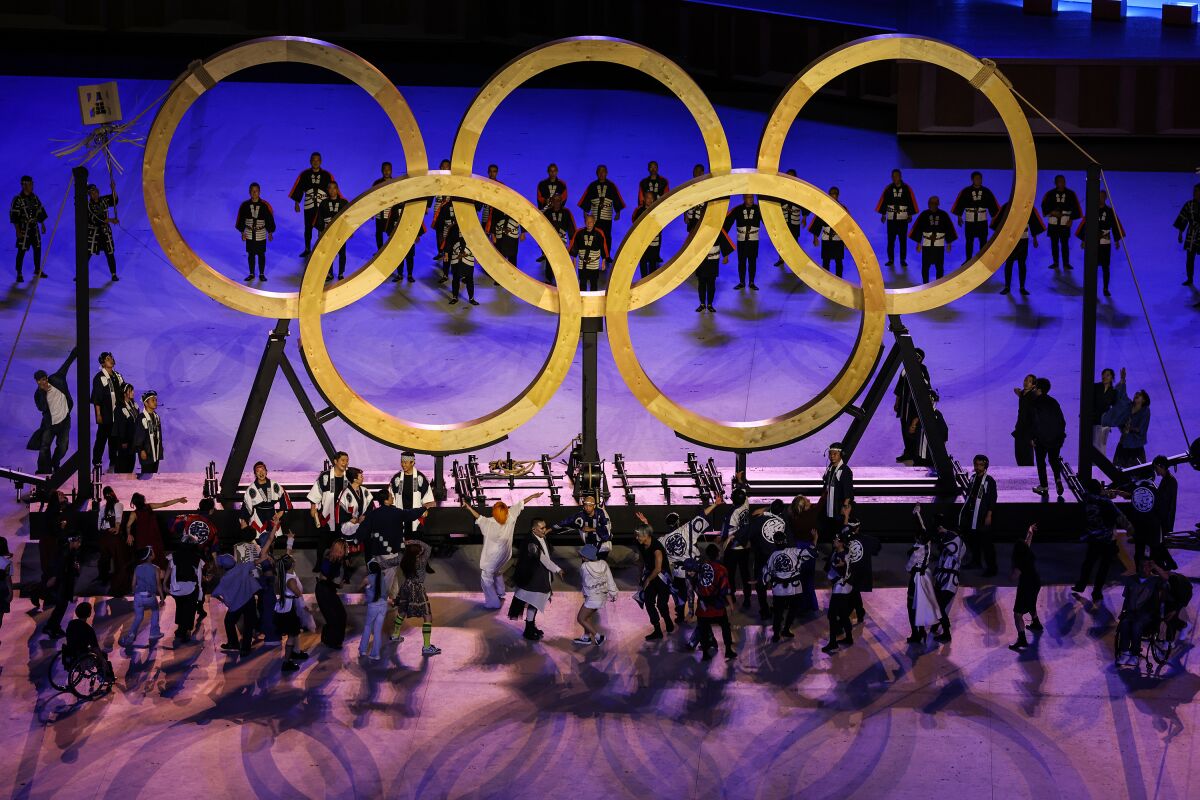 Olympic rings are assembled amid performers during the Tokyo Olympics opening ceremony.