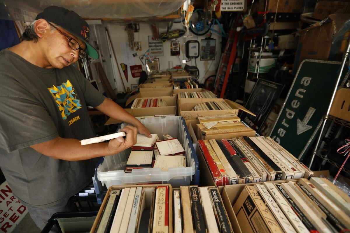 Mike Nishita looks over tapes from one of the world's greatest musical archives, stored in his garage in Gardena, Calif.