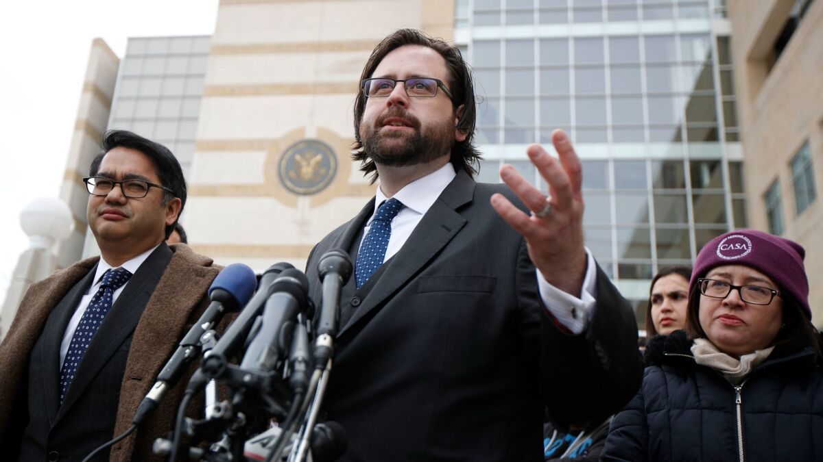 Justin Cox of the National Immigration Law Center, center, stands with Omar Jadwat of the American Civil Liberties Union outside the federal courthouse in Greenbelt, Md., after a hearing over the travel ban on March 15. (Manuel Balce Ceneta / AP)