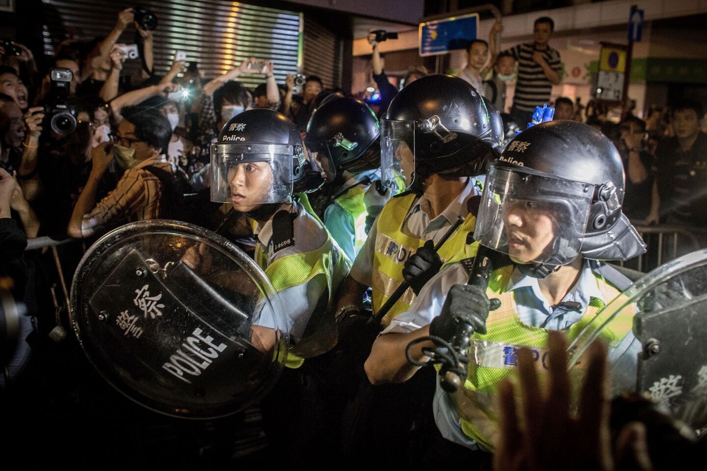 Pro-democracy protesters push against police as they break down barricades and retake streets in Mong Kok.