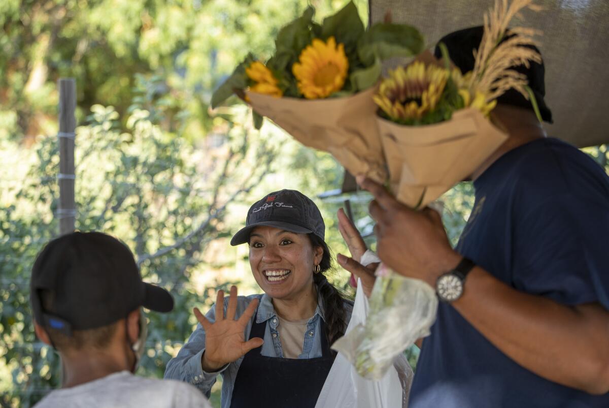 Farmer Liset Garcia chats with customers at her Sweet Girl Farms 