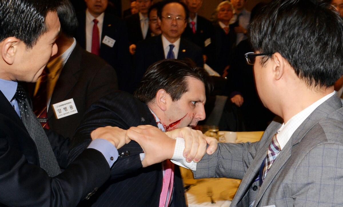 A wounded Mark Lippert leaves the Sejong Cultural Institute in Seoul after a knife attack on March 5.