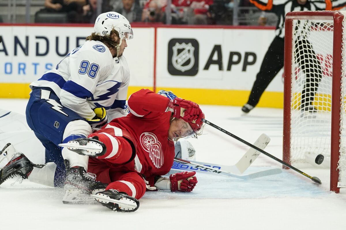 Detroit Red Wings left wing Tyler Bertuzzi (59) scores as Tampa Bay Lightning defenseman Mikhail Sergachev (98) defends in the second period of an NHL hockey game Thursday, Oct. 14, 2021, in Detroit. (AP Photo/Paul Sancya)