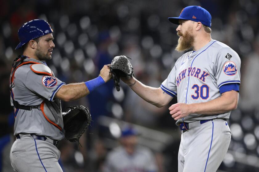 New York Mets relief pitcher Jake Diekman (30) and catcher Luis Torrens, left, celebrates after a baseball game against the Washington Nationals, Monday, June 3, 2024, in Washington. (AP Photo/Nick Wass)