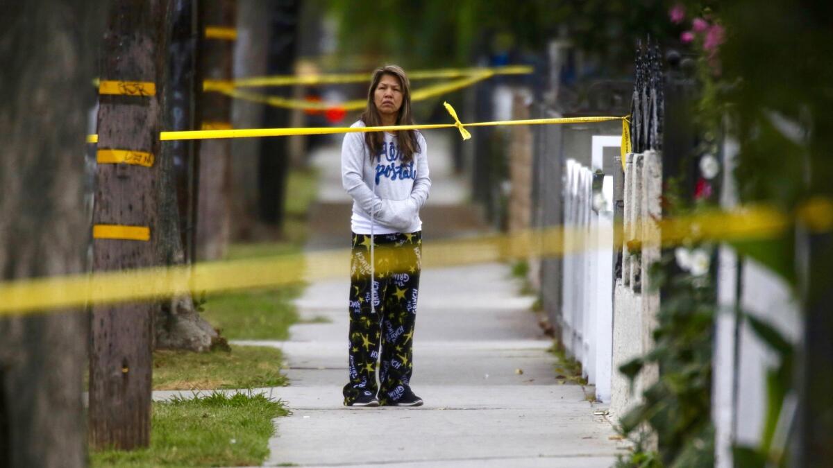 A neighbor watches the investigation in the 900 block of North Santa Fe Avenue in Compton.