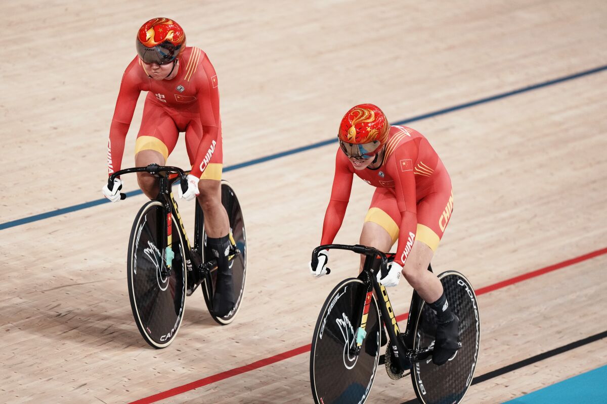 Tianshi Zhong, left, and Shanju Bao of Team China compete during a qualifying heat for track cycling women's team sprint at the 2020 Summer Olympics, Monday, Aug. 2, 2021, in Izu, Japan. (AP Photo/Thibault Camus)